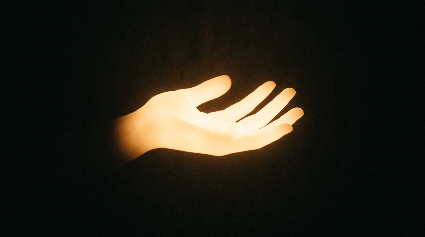 Warm glowing hand silhouette offering support